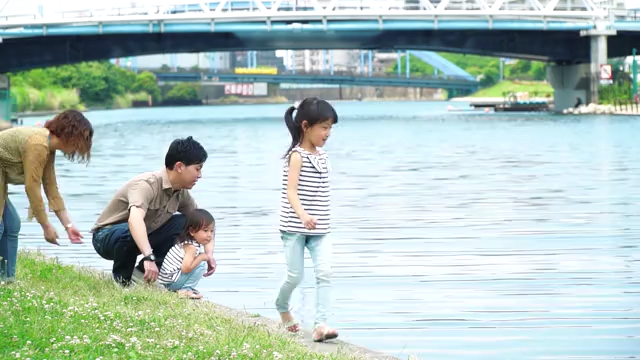 河辺で遊ぶ家族