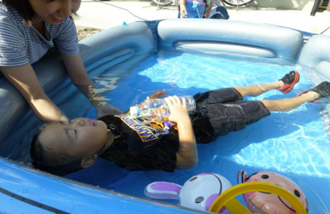 子供用プールで“浮いて待て”を実践する子供